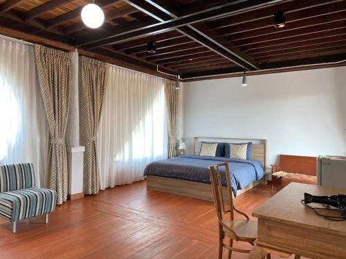 Ban Mae Choบ้านวิวนา Baan View Na的卧室配有一张床和一张桌子及椅子