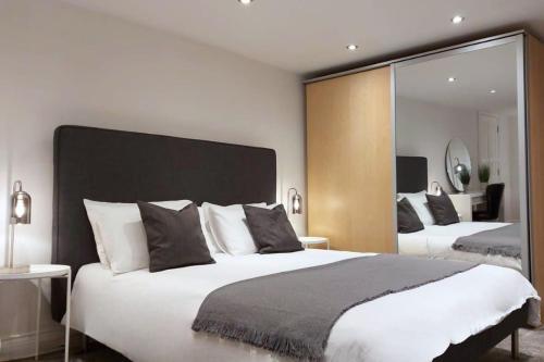 普雷斯顿2 Bedroom City Centre Duplex Apt的一间卧室设有两张床和大镜子