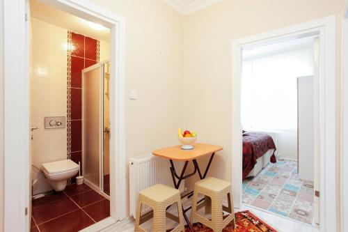 伊斯坦布尔蓝色苏丹公寓式酒店的一间带卫生间的浴室和一张带两个凳子的桌子