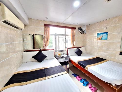 香港International Metro Guest House的小型客房 - 带2张床和窗户