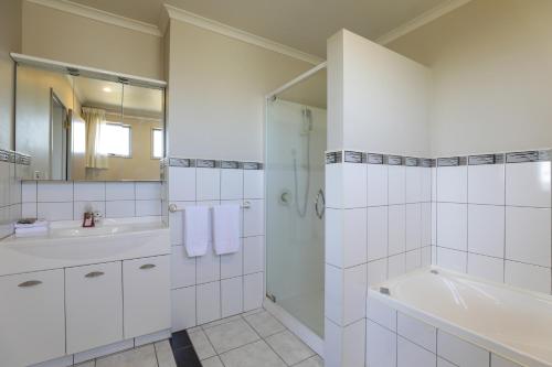 陶波Top of the Lake - Taupo的白色的浴室设有淋浴、浴缸和水槽。