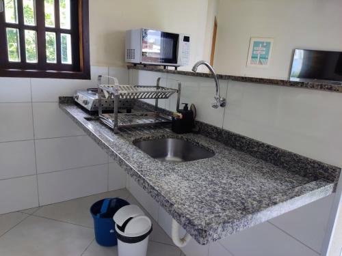 伊利亚贝拉Casa Azul Perequê的厨房柜台设有水槽和微波炉