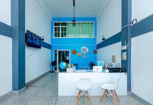 Ban SuaniTalay Krabi的办公室设有蓝色的墙壁和白色的椅子