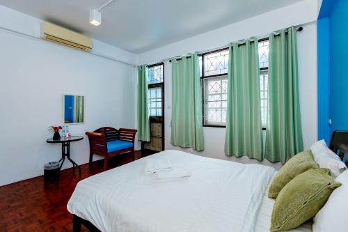 Ban SuaniTalay Krabi的卧室配有白色的床和绿色窗帘
