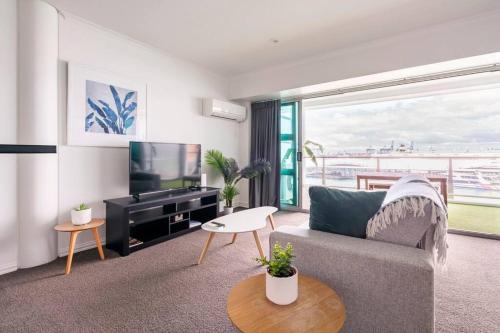 奥克兰Luxury Apartment With Stunning Harbour & City View的带沙发和平面电视的客厅
