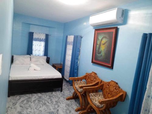 安达Anda Home at Cabagnow Cave Pool的蓝色卧室,配有床和两把椅子