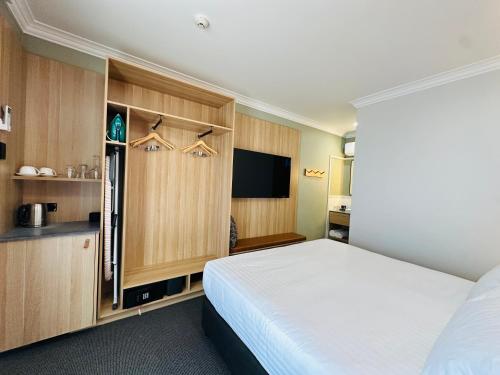 莫里Royal Hotel-Motel的一间卧室配有一张床和一台平面电视