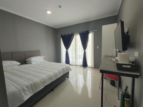 MaribagoCASABLU HOTEL&RESORT的一间卧室配有一张床、一张书桌和一个窗户。
