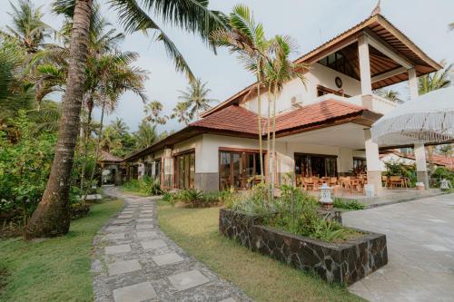 BalianBali Hai Island Resort的前面有棕榈树的房子