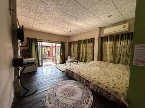 清迈Villa’s Homestay的一间卧室配有一张床,并在一间客房内配有电视。