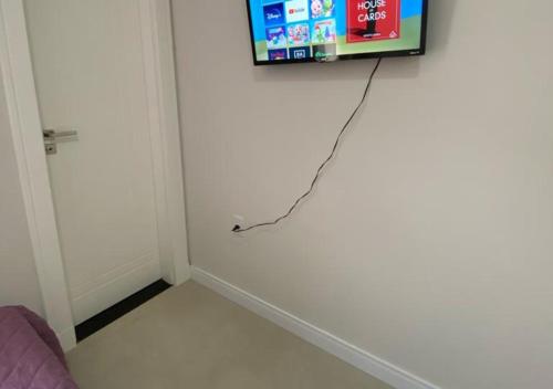 伊达贾伊Suíte Premium的白色墙上有绳子的电视