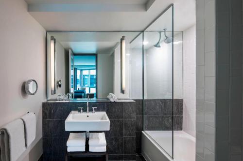 霍博肯霍博肯W酒店的一间带水槽、浴缸和镜子的浴室