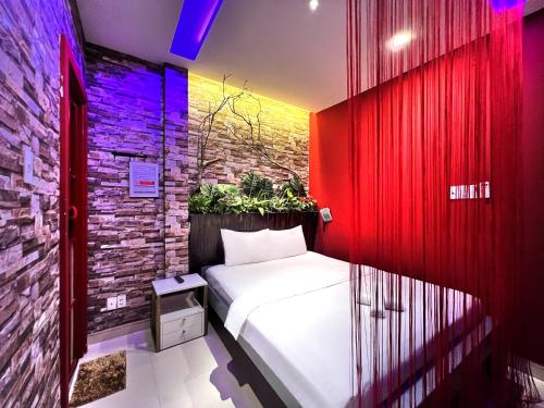 胡志明市Loove Hotel - Khách Sạn Tình Yêu的一间卧室设有一张床和砖墙