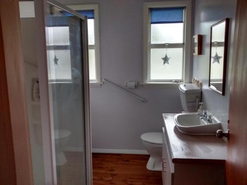 TuamarinaSunrise Beach House - Rarangi Holiday House的浴室配有卫生间、盥洗盆和淋浴。