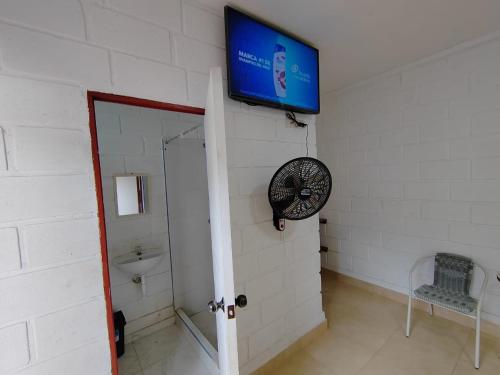 塔拉波托Hospedaje Los Jazmines de Santa Rosa的带电视的浴室和墙上的风扇