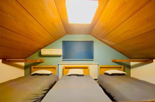 白马村Pyrenees Cottage - Vacation STAY 24861v的带电视的小型客房中的两张床