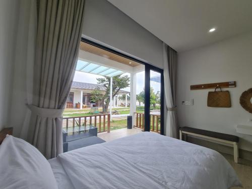 潘郎Myhoa Lagoon - Kiting Town的一间卧室设有一张床和一个大窗户