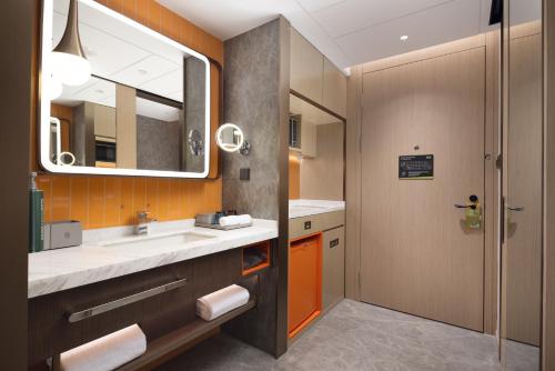 花都广州白云机场西希尔顿惠庭酒店的一间带水槽和镜子的浴室