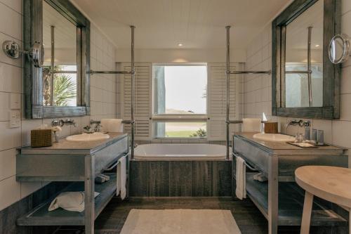 Matauri BayRosewood Kauri Cliffs的浴室配有两个盥洗盆和浴缸。