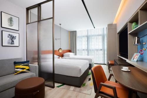 花都广州白云机场西希尔顿惠庭酒店的酒店客房设有两张床和一张桌子。