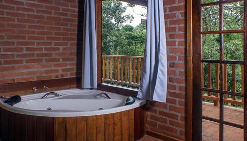 圣安东尼奥-杜皮尼亚尔Espaço Recanto do Pico的窗户客房内的浴缸