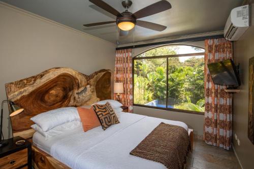 奎波斯城Villa with jungle view & pool near Manuel Antonio的一间卧室设有一张床和一个大窗户