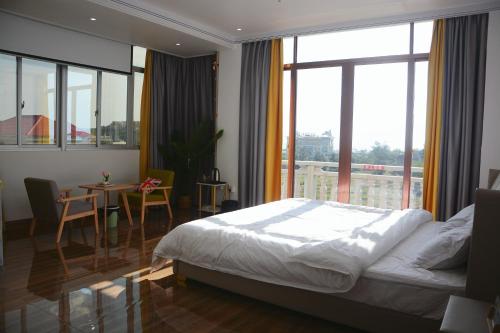 梅州湄洲岛悦榕湾民宿的一间卧室配有一张床、一张桌子和一个大窗户
