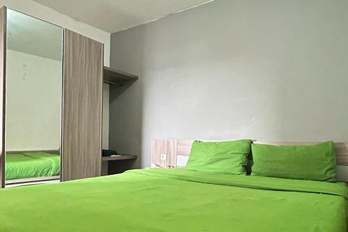 当格浪Barata Home的一间卧室配有绿色的床和镜子