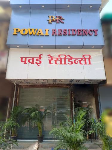 孟买Hotel Powai Residency的前面有植物的餐厅的标志