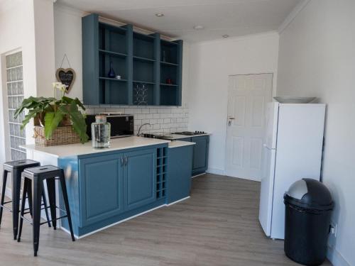 比勒陀利亚Kelkiewyn Waterkloof Guesthouse的厨房配有蓝色橱柜和白色冰箱
