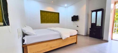 戴维格Shivansh Cottage Diveagar的一间卧室配有一张带白色床单的床和一扇窗户。