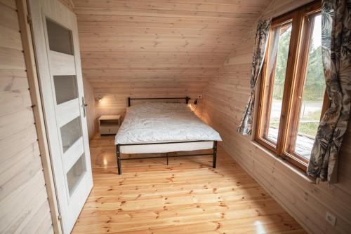厄尔科Mazury w Pigułce- domek z sauną i balią, Woszczele的一间小卧室,小房子里配有一张床