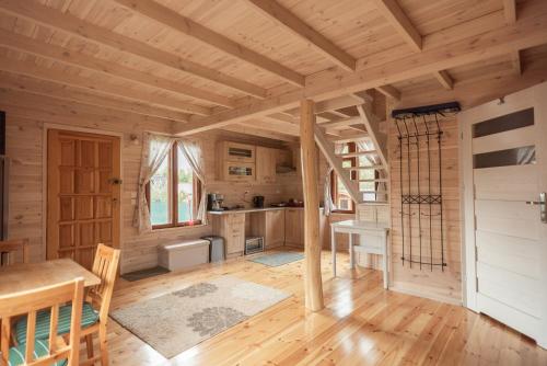 厄尔科Mazury w Pigułce- domek z sauną i balią, Woszczele的小木屋厨房铺有木地板,设有门