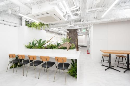 大阪ZONE SHINSAIBASHI WEST的会议室设有椅子和植物台面