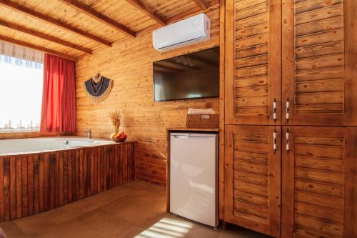 厄吕代尼兹Ölüdeniz Manzara Non Alcoholic Family Hotel的厨房配有木制橱柜和白色冰箱。