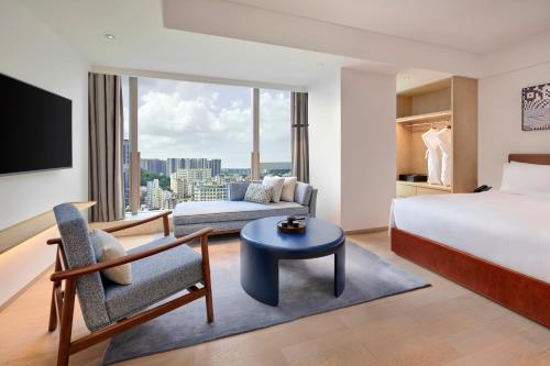 深圳深圳机场希尔顿逸林公寓的酒店客房,配有床和沙发