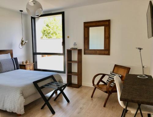 阿斯克新城HÔTELYA - Lille Villeneuve d'Ascq的卧室配有1张床、1张桌子和1把椅子