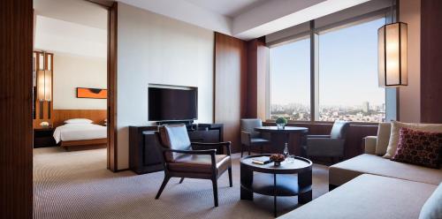 长春长春凯悦酒店的带沙发的客厅和带电视的客房。