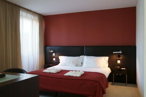 里斯本热罗尼姆斯8号酒店的酒店客房,配有带毛巾的床