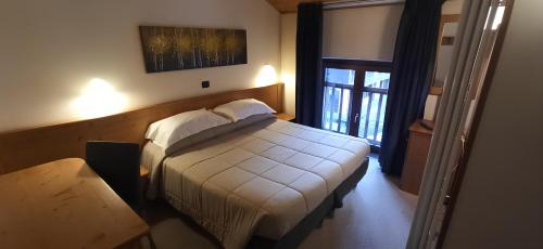 普雷圣迪迪埃阿尔佩奇亚拉酒店的一间带床的卧室,位于带窗户的房间内