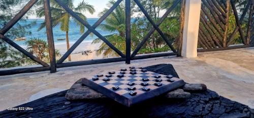 吉汶瓦Ayla Beach House的海滩景客房的一张桌子上棋盘