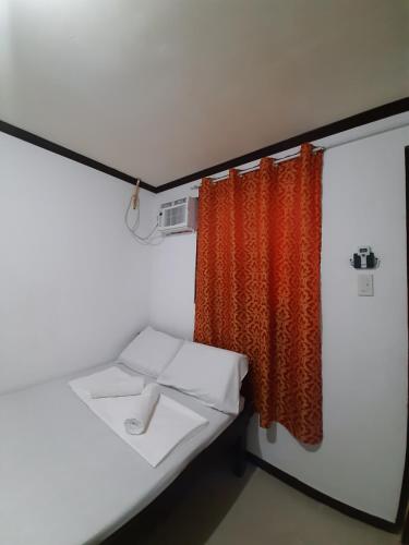 BurgosSubangan Room 6的橙色窗帘和床的房间