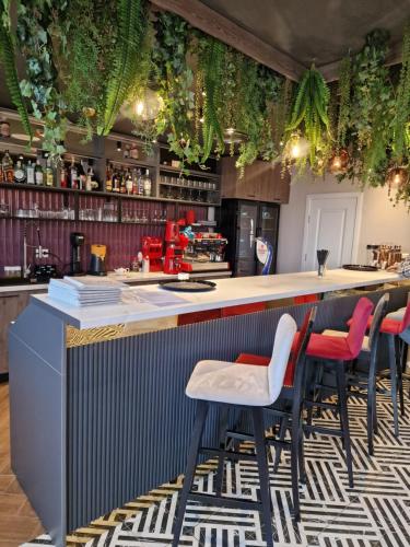 加拉茨Hotel City Break的厨房设有酒吧,配有红色和白色凳子