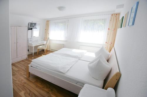 古梅尔斯巴赫Garni Hotel Bodden的卧室配有白色的床和书桌