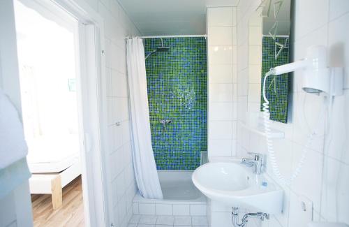 古梅尔斯巴赫Garni Hotel Bodden的白色的浴室设有水槽和淋浴。