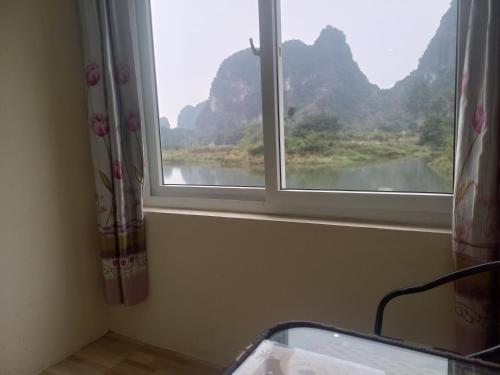 宁平Trang An Pristine View homestay的享有河流和山脉美景的窗户。