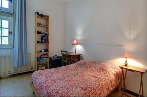 艾马尔格Château Teillan - Cadran solaire的一间卧室配有一张床、一张书桌和一个窗户。