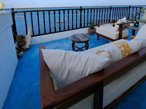 拉穆Pwani House - Lamu Seafront的房屋阳台的一张床位