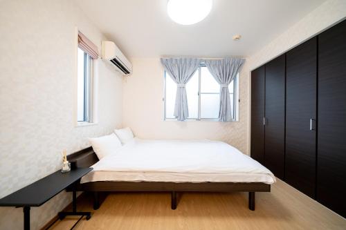 东京Shinokubo guest house的一间卧室设有一张床和一个窗口