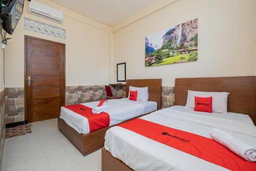 玛琅RedDoorz Syariah near Batu Night Spectacular的一间卧室配有两张红色和白色床单